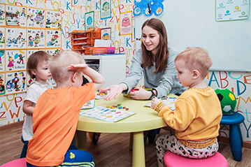 Дети дают пять учителю в детском саду Взмах